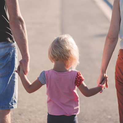 Child holding hands with 2 adults, image for Family Litigation in Qualicum Beach